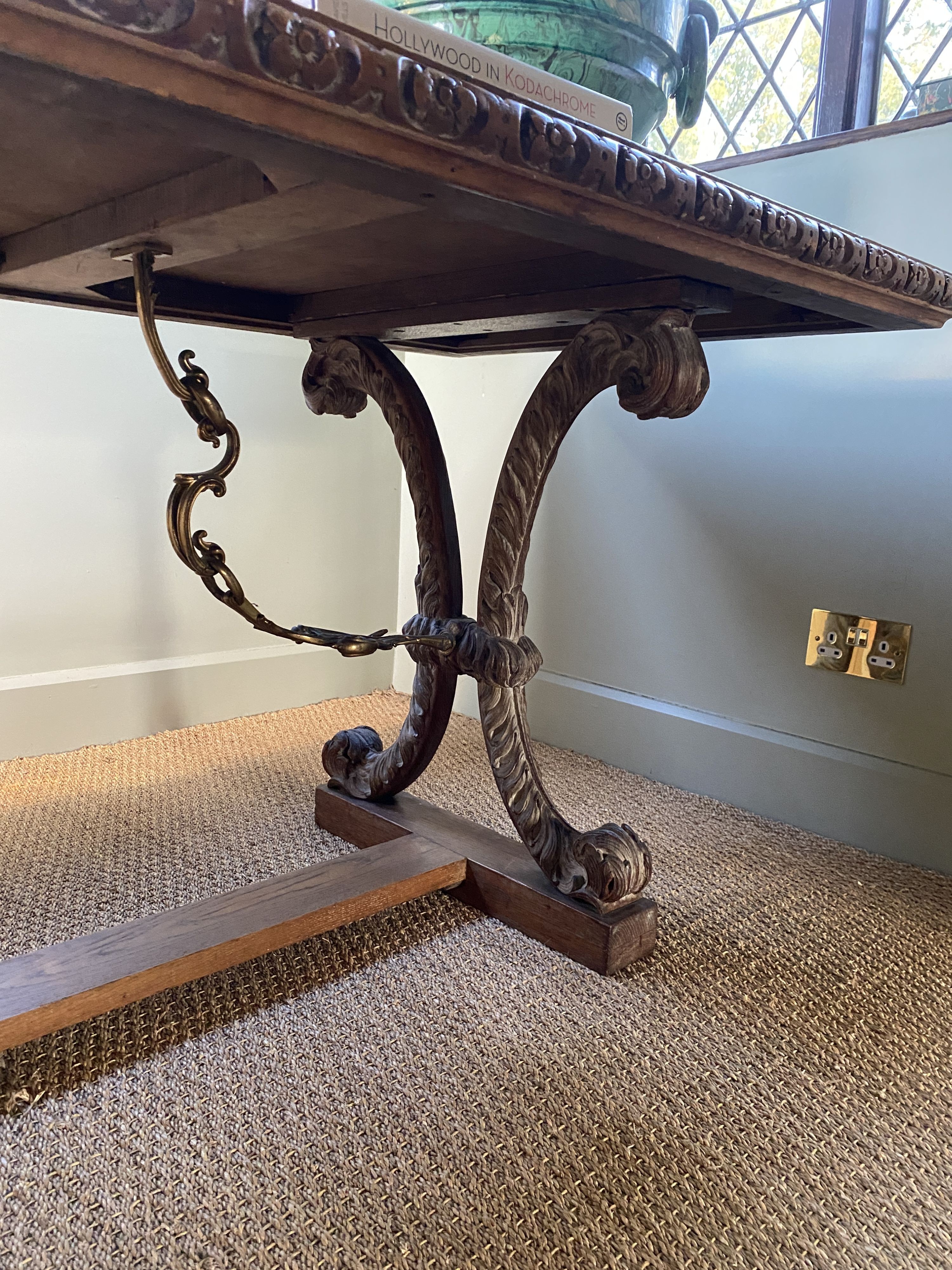 A Spanish style crossbanded walnut centre table, with floral carved border and gilt metal mounted scrolling foliate X shaped supports, width 197cm depth 82cm height 76cm